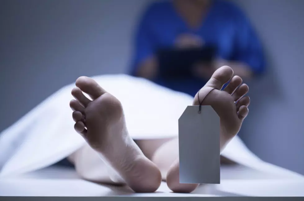 Dead Body On Gurney Falls From The Back Of Coroner’s Van, Comes To Rest In An Intersection